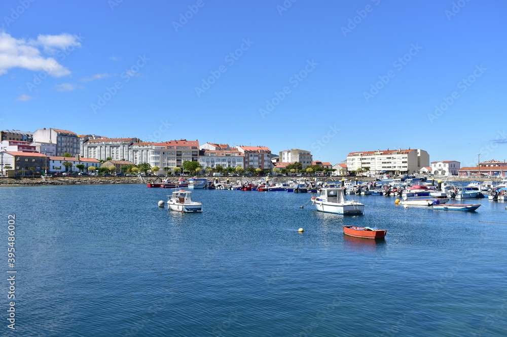 Harbour and coastal village with galician fishing vessels, rowboats and sailing boats at famous Rias Baixas in Galicia Region. Portosin, Coruña, Spain.

