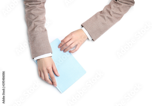 Woman with notebook on white background, top view. Closeup of hands