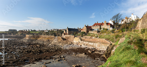 A panorama of the beautiful little cove at Crail, Fife, Scotland. The tide is out, exposing the rocky coastline, that is so good for rock pooling. At higher tides the waves smash against the sea wall.