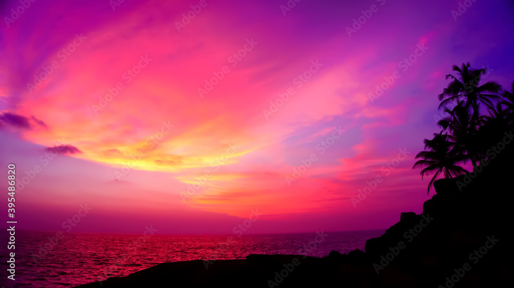 Sunset on the beach. Sri lanka beach view, Unavatuna. Best beach in the world. Palms silhouette on the purple and pink sky background.