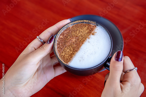 Girl's hand hold Traditional Turkish Drink Salep. Turkish salep (milky traditional hot drink). photo