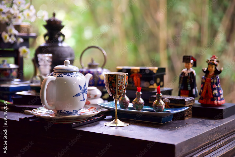 teapot and decorative wine glass in focus on the foreground, tea ceremony in the east, clay teapot and green tea cup, Chinese tradition of tea drinking teapot and decorative wine glass in focus on the foreground, tea ceremony in the east, clay teapot and green tea cup, Chinese tradition of tea drinking