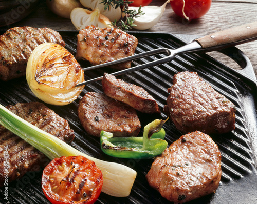 Various meats and vegetables on a grill