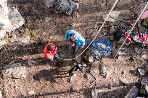 male climber with a frend stand a rock with rope top view photo