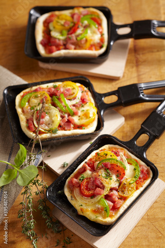 Mini, oven-baked raclette pizzas with cheese and vegetables photo