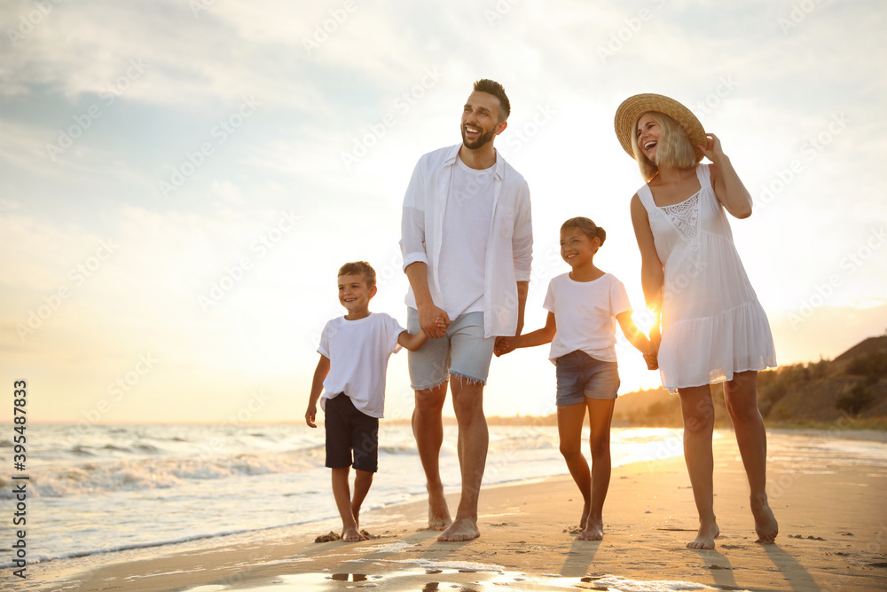 © New Africa - Happy family walking on sandy beach near sea at sunset
