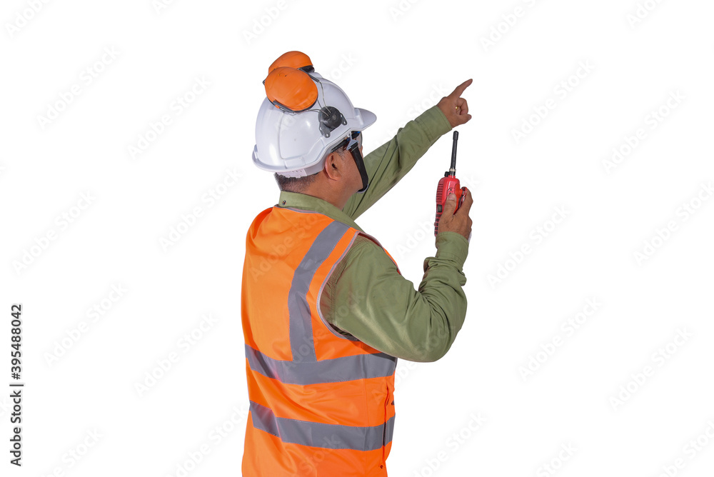 The Engineer standing wearing safety helmet with wearing reflective jacket and pointed a finger in his hand holding walkie-talkie isolated on white background. The Engineer standing wearing safety helmet with wearing reflective jacket and pointed a finger in his hand holding walkie-talkie isolated on white background.