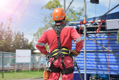 Safety man standing wearing safety helmet in construction following wearing equipment safety harness PPE