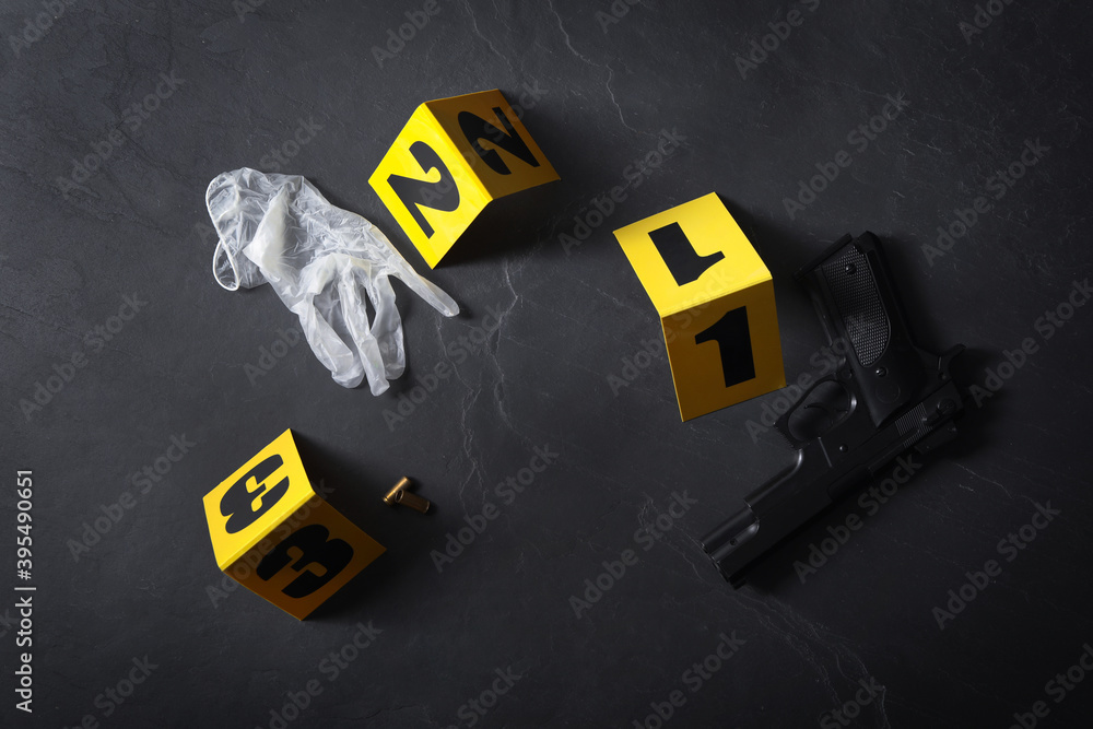 Flat lay composition with evidences and crime scene markers on black background Flat lay composition with evidences and crime scene markers on black background