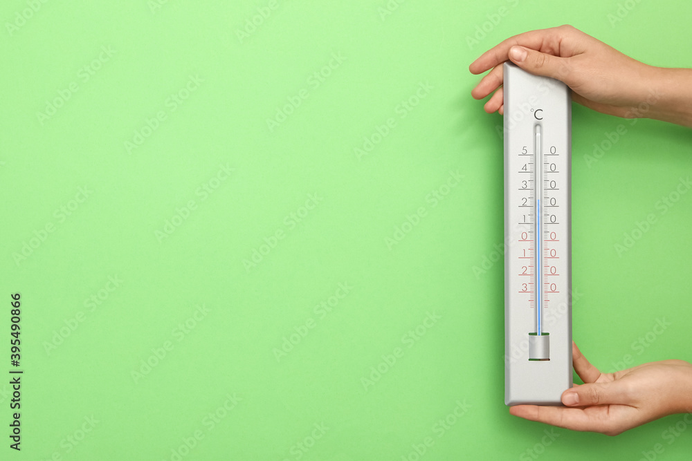 Woman with weather thermometer on green background, closeup. Space for text Woman with weather thermometer on green background, closeup. Space for text