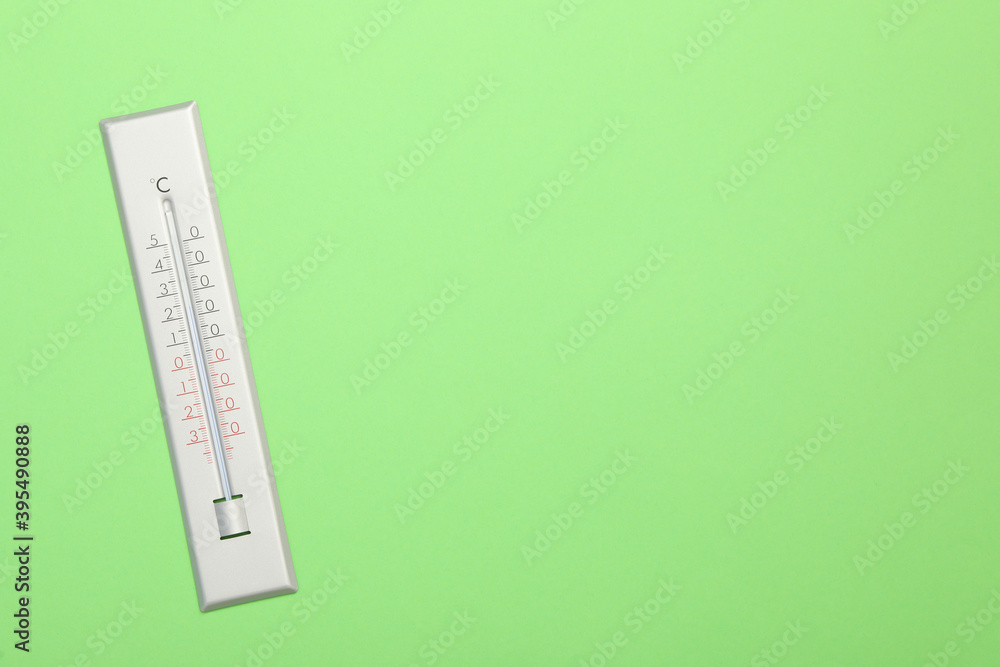 Weather thermometer on green background, top view. Space for text Weather thermometer on green background, top view. Space for text
