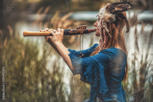 Obraz na plátně beautiful shamanic girl playing on shaman flute in the nature.