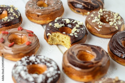 Various doughnuts with chocolate glaze, one with a bite taken out