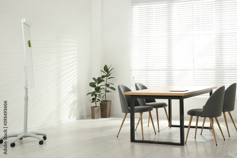 Fototapeta premium Conference room interior with wooden table and flipchart