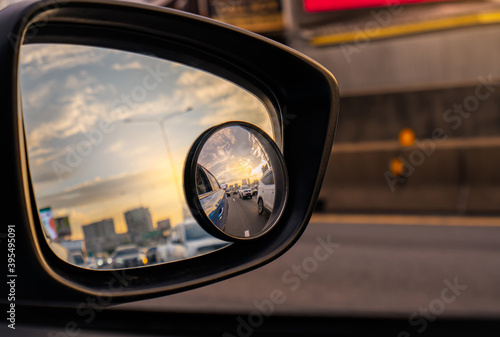 Papier peint Reflection of traffic flow on asphalt road in side mirror of blue SUV