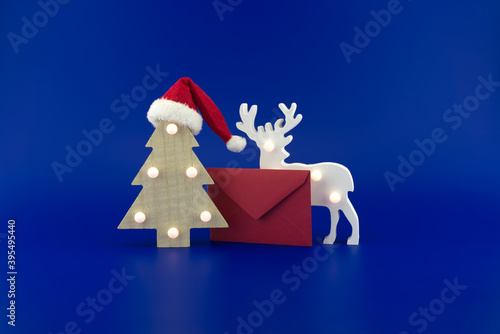 Christmas tree next to red envelope and reindeer