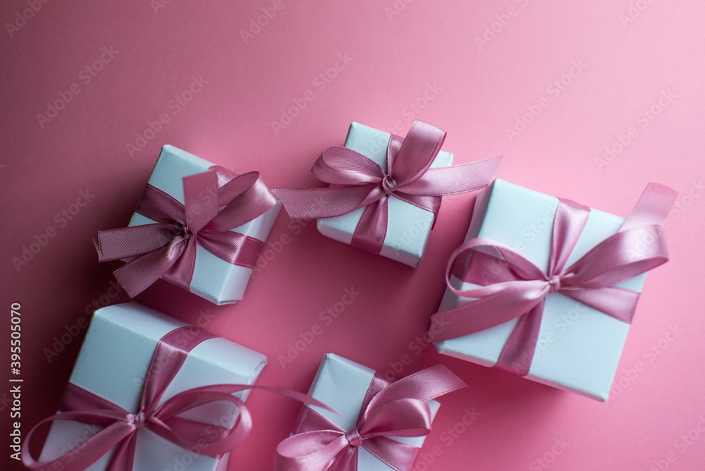 Gift or present box with shiny balls, ribbons and snowflakes on pink background. Flat lay composition for christmas, female Christmas. White gift with pink ribbons. A gift box isolated on pink Gift or present box with shiny balls, ribbons and snowflakes on pink background. Flat lay composition for christmas, female Christmas. White gift with pink ribbons. A gift box isolated on pink