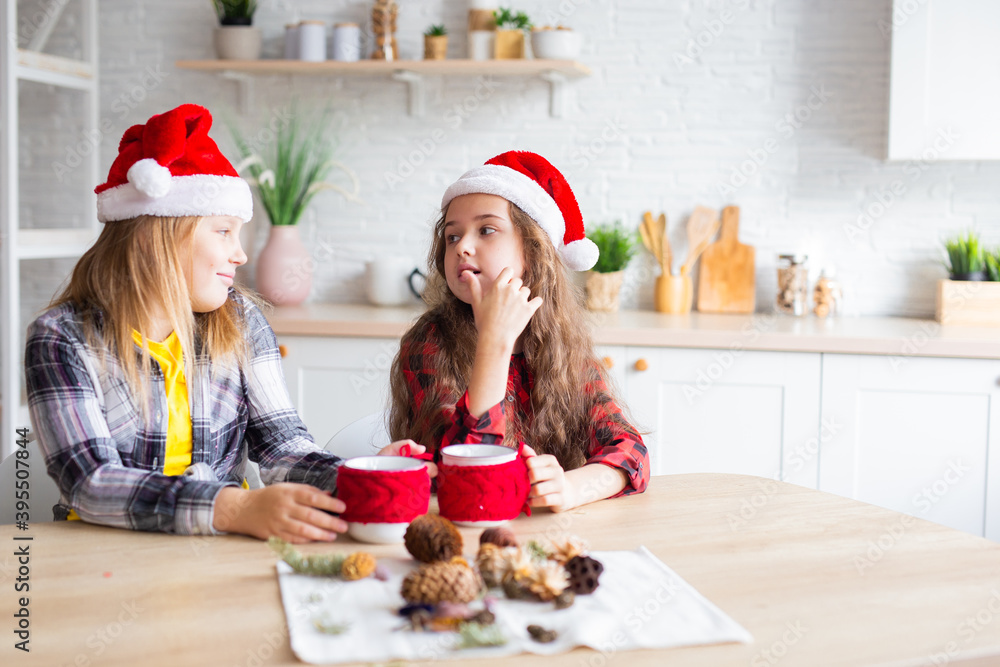 Merry Christmas and Happy Holidays! Cheerful cute kid girls having fun. Children in Santa hats have fun at breakfast in the morning. Loving family Merry Christmas and Happy Holidays! Cheerful cute kid girls having fun. Children in Santa hats have fun at breakfast in the morning. Loving family