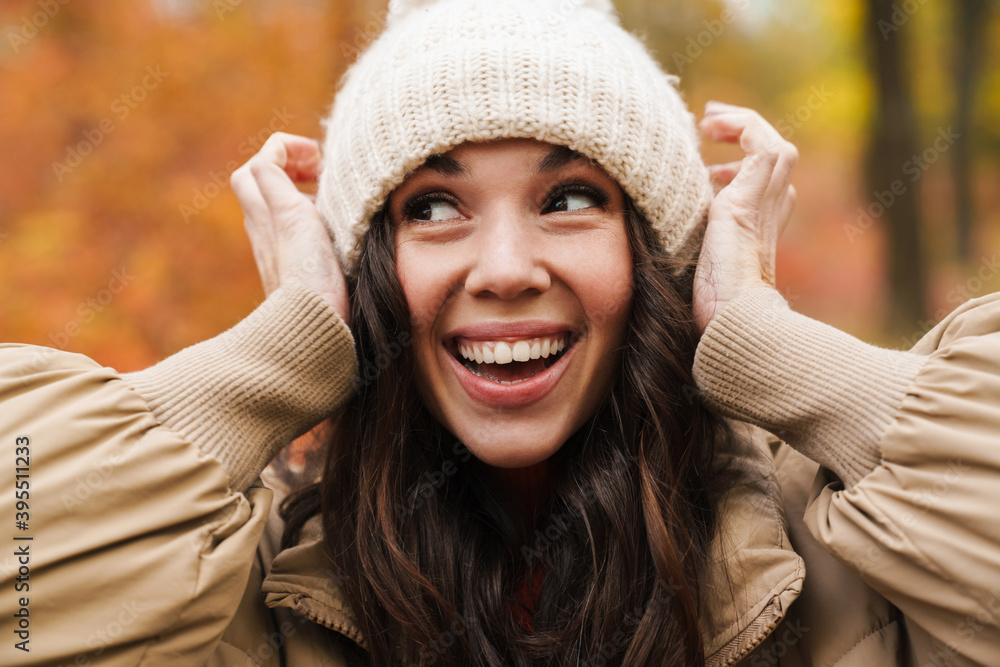 Beautiful cheerful woman laughing and making fun with knit hat Beautiful cheerful woman laughing and making fun with knit hat