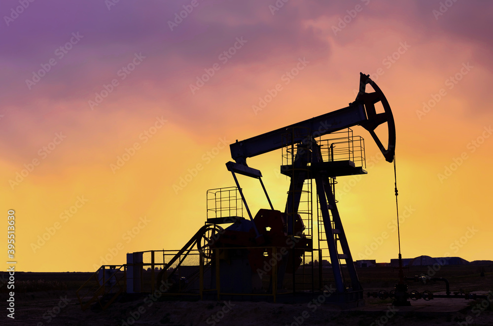 Crude oil pump jack at oilfield on atmospheric sunset backround. Fossil crude output and fuels oil production. Oil drill rig and drilling derrick. Global crude oil Prices, energy, petroleum demand Crude oil pump jack at oilfield on atmospheric sunset backround. Fossil crude output and fuels oil production. Oil drill rig and drilling derrick. Global crude oil Prices, energy, petroleum demand