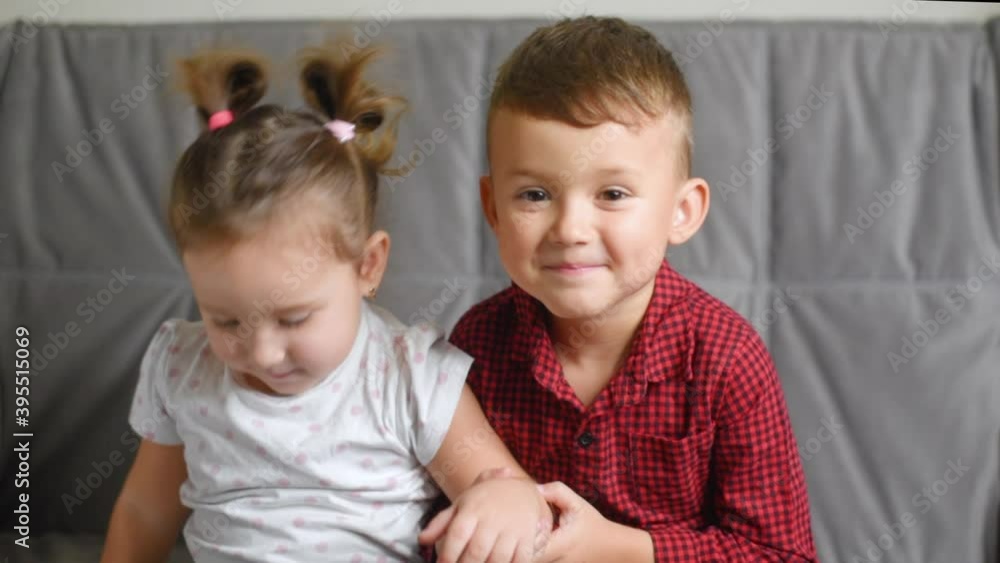Little sister kissing her brother sitting on the couch Little sister kissing her brother sitting on the couch