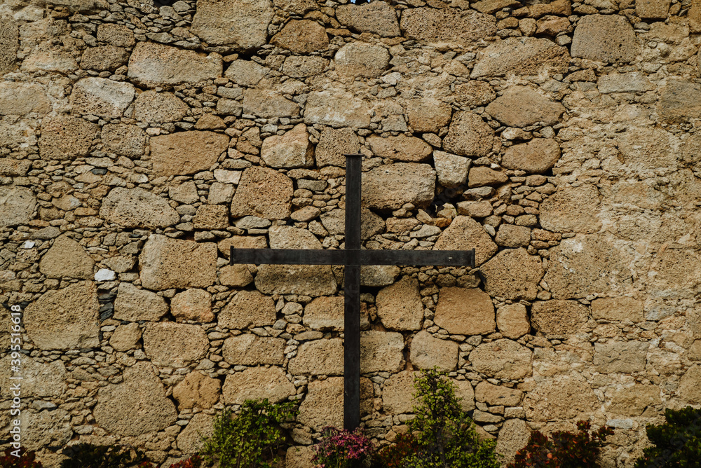 old stone cross on the wall. Old wooden cross on stone background