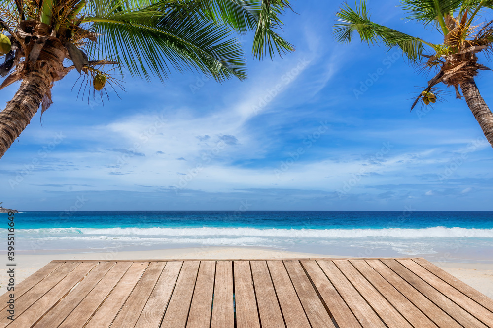 Empty wooden table and coconut palms with party on tropical beach background. Concept of beach party in summer vacations. Empty wooden table and coconut palms with party on tropical beach background. Concept of beach party in summer vacations.