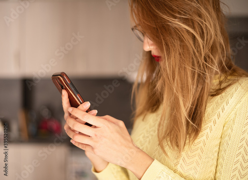 Millennial woman checks social networks and holds a smartphone. The girl influencer checks her post on the social network.