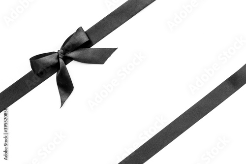 Black ribbon with bow isolated on white. Top view, copy space
