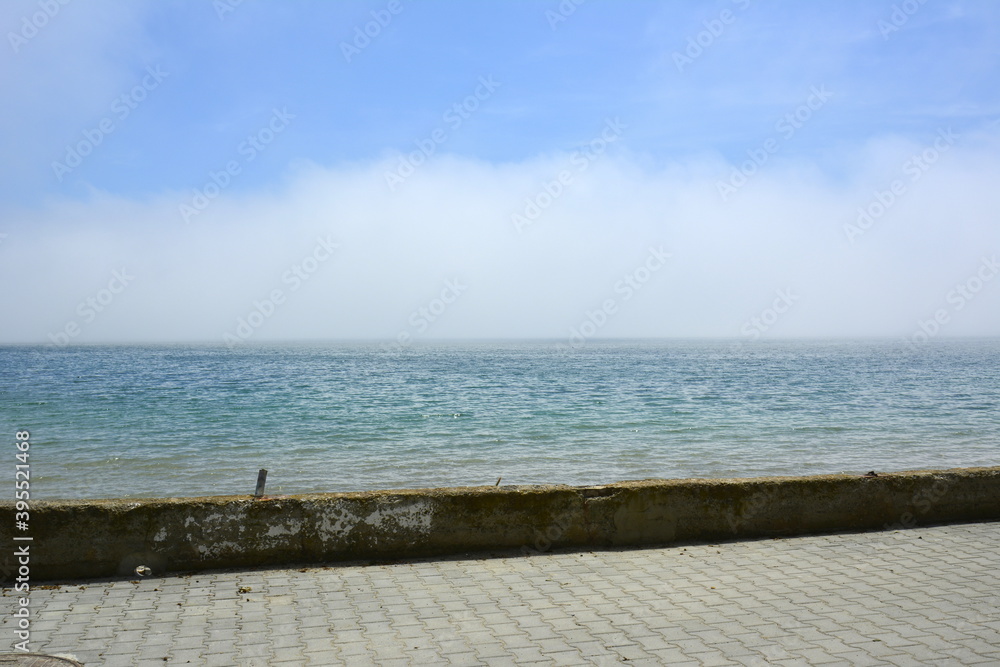 Ravda, Bulgaria. May, 20, 2014. Seashore with white cloud covering water. Promenade edge with no people