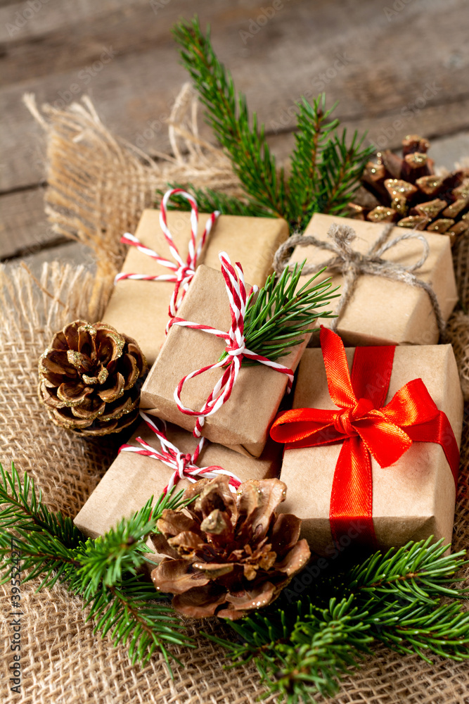 Christmas gift boxes in ecofriendly craft paper. Gifts in a wooden box on a wooden table. Eco-friendly gift packaging Christmas gift boxes in ecofriendly craft paper. Gifts in a wooden box on a wooden table. Eco-friendly gift packaging