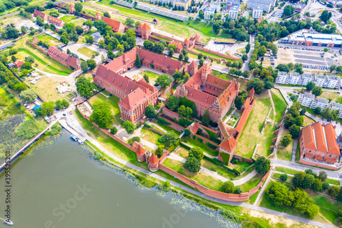 Medieval Malbork (Marienburg) Castle in Poland, main fortress of the Teutonic Knights at the Nogat river. Aerial skyline view of the city in fall in sunset light