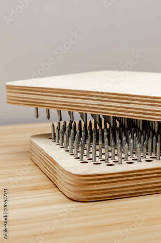 Sadhu wooden board with nails for sadhu practice. On bamboo desk and white background.