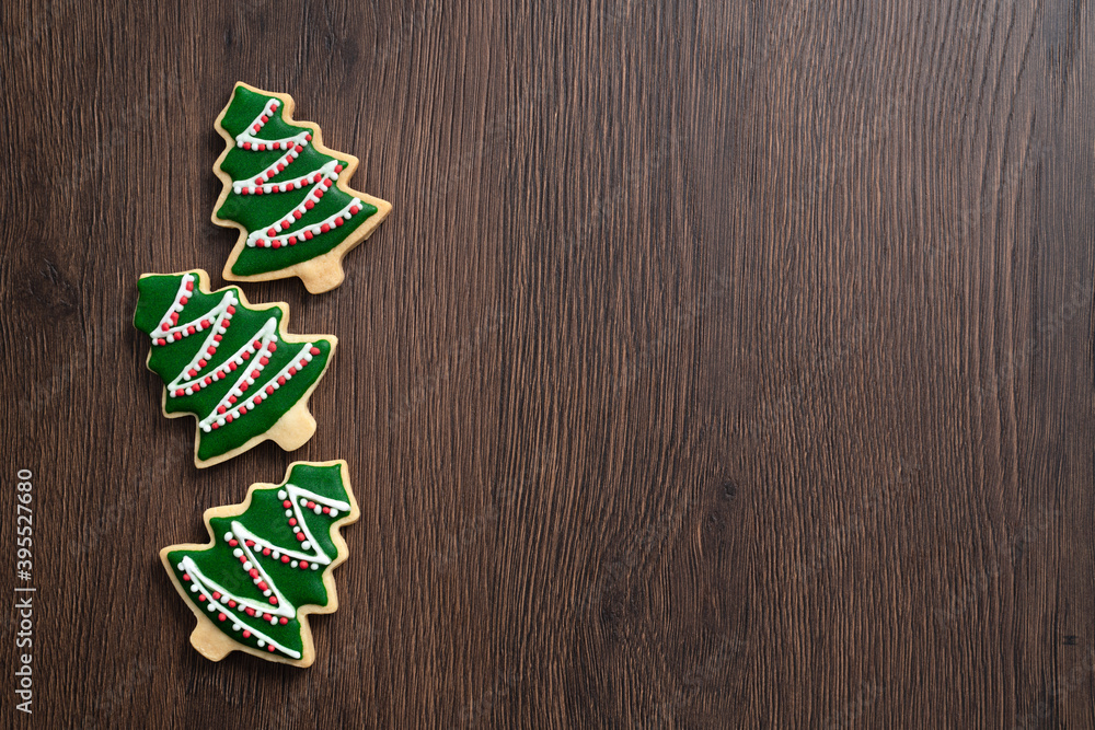 Top view of decorated Christmas tree cookie on wooden table background with copy space.