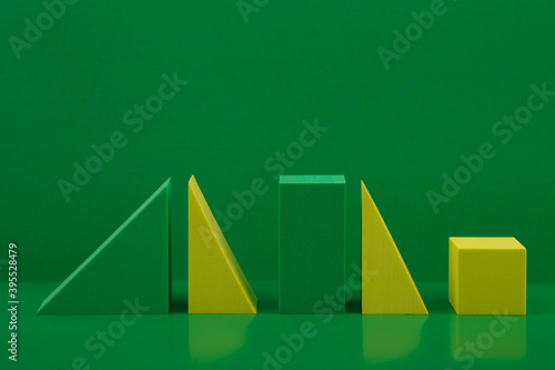 Foto Duotone still life with yellow and green geometric figures on a green background