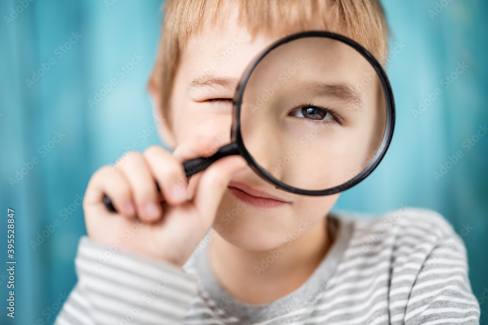 Little boy looking through a magnifying glass Little boy looking through a magnifying glass