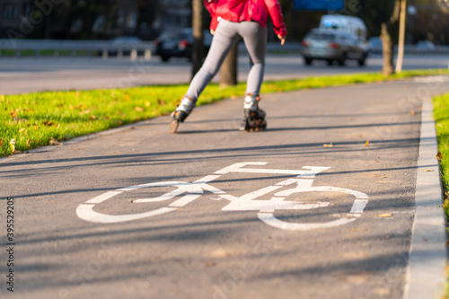 Active leisure. A sportive girl is rollerblading in an autumn park