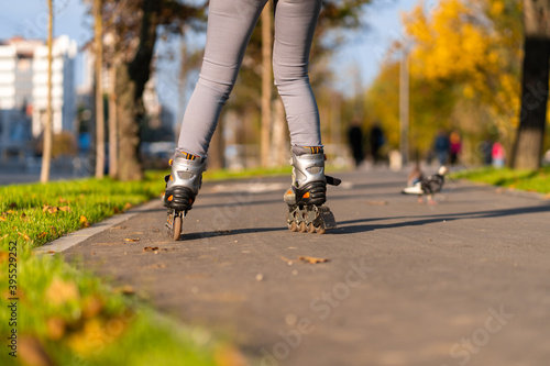 Active leisure. A sportive girl is rollerblading in an autumn park