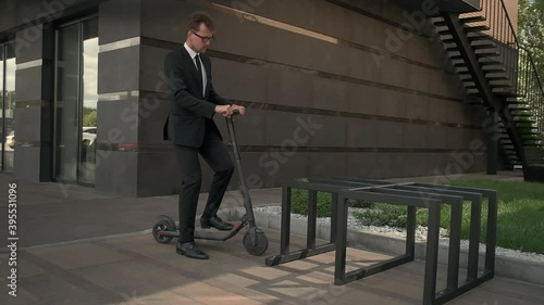businessman is parking scooter near office center