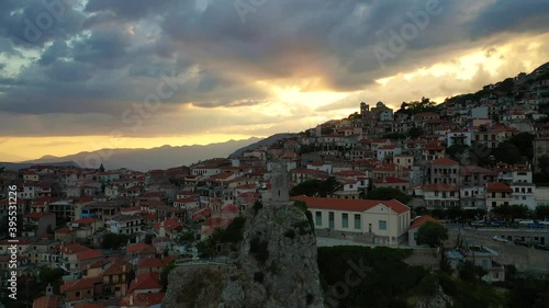 Aerial drone video of beautiful sunset with golden colours and clouds over old landmark clock tower in picturesque and traditional village of Arachova, Viotia prefecture, Greece photo