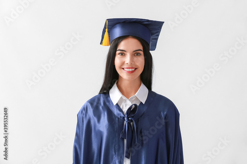 Female graduating student on light background