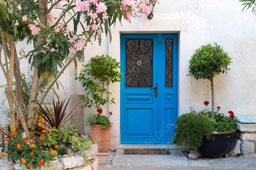 Beutiful vintage courtyard with lush greenery and marine blue wooden door in old Mediterranean costal town, Croatia. © kasto