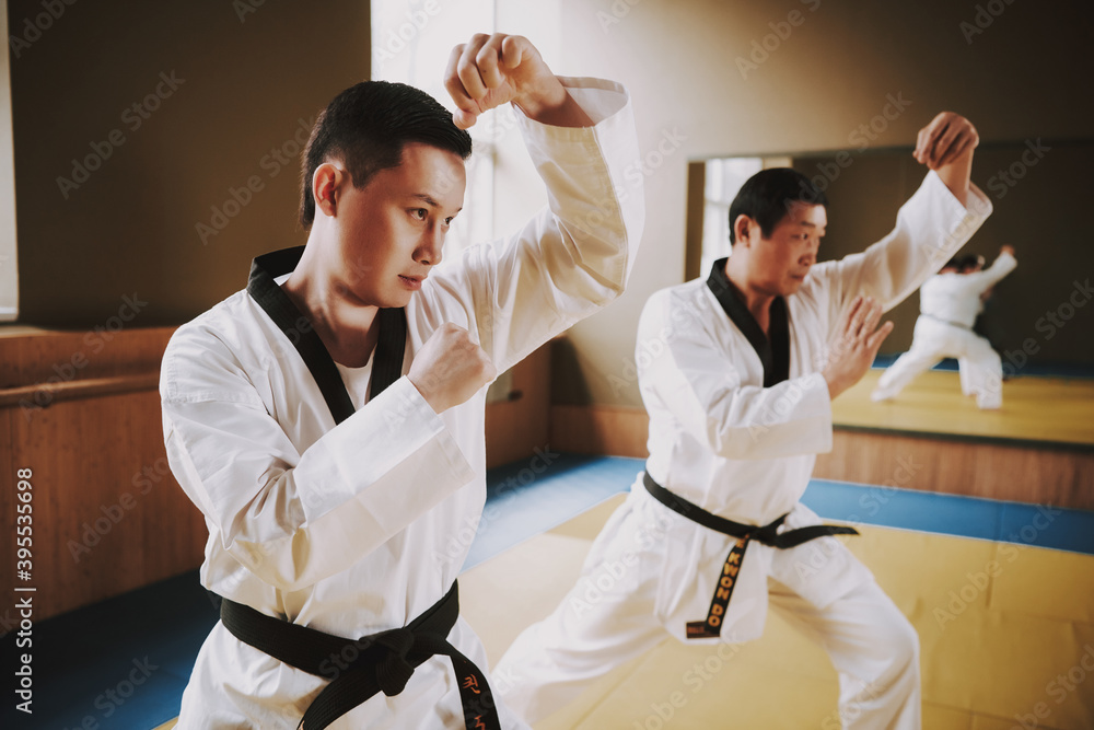 Obraz premium Two men work out tricks while standing in the gym.