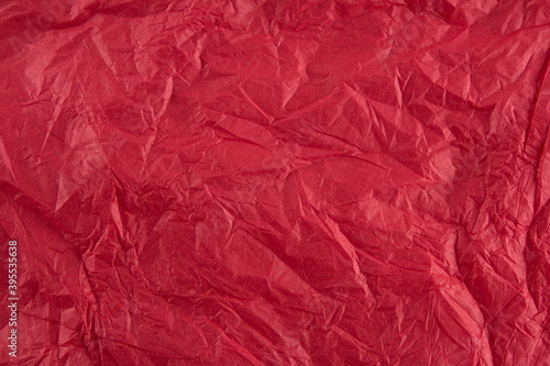 Background with red crumpled sheet of fabric with vignetting.