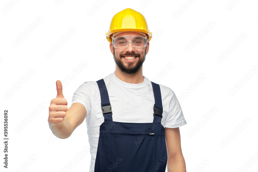 profession, construction and building - happy smiling male worker or builder in yellow helmet and overall showing thumbs up over white background