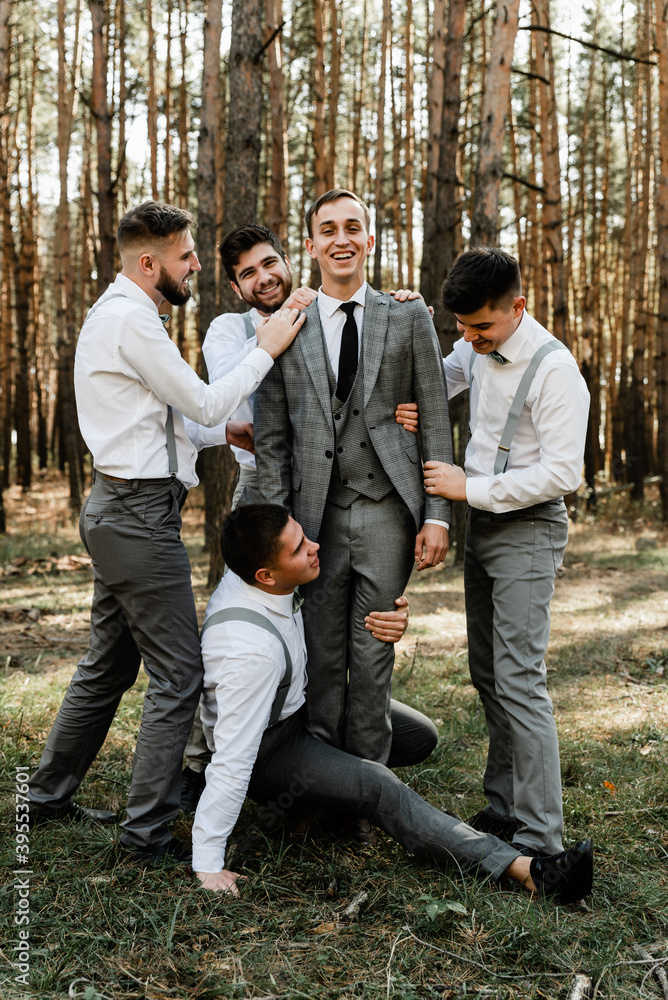 groom and his funny friends having fun on the wedding day of the newlyweds, a group of guys fooling around, stylish wedding