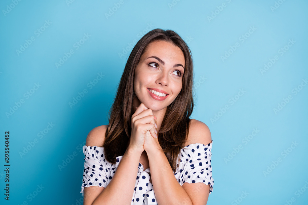Photo of lovely dreamy girl beaming smile look empty space wear dotted blouse isolated blue color background Photo of lovely dreamy girl beaming smile look empty space wear dotted blouse isolated blue color background