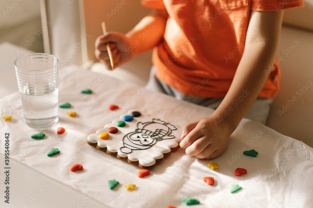 A child paints glazed gingerbread cookies with food coloring. Creativity and hobbies A child paints glazed gingerbread cookies with food coloring. Creativity and hobbies