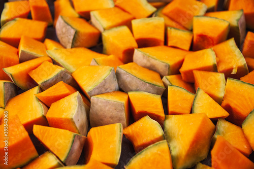 The choped raw pumpkin texture, closeup. Flat lay of freshly cut vegetables. Concept of healthy lifestyle, vegan diet