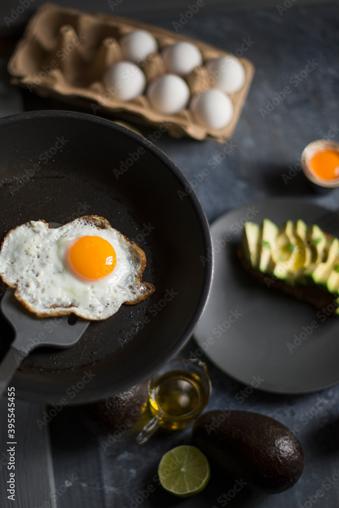 A fried egg in a pan served with fresh avocado for breakfast A fried egg in a pan served with fresh avocado for breakfast